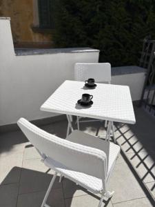 a white table and two chairs on a balcony at Suite Casina al Lago in Lavena Ponte Tresa +15 photos