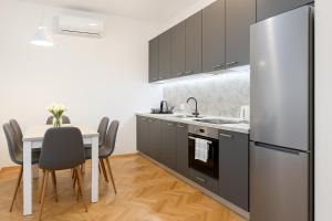 a kitchen with a table and a refrigerator at Deluxe Apartments Zagreb in Zagreb