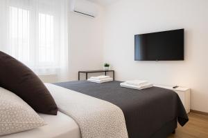 a bedroom with a bed and a flat screen tv at Deluxe Apartments Zagreb in Zagreb
