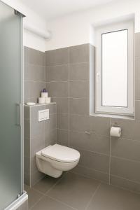a bathroom with a toilet and a window at Deluxe Apartments Zagreb in Zagreb +15 photos