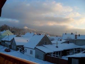 a town covered in snow with a mountain in the background at Apartmány Prima-Pokoje in Mimoň