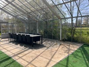a glass greenhouse with a table and chairs in it at Hotel Margrethe in Gadbjerg