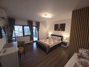 a bedroom with a bed and a table and chairs at River Star in Sîngeorgiu de Pădure