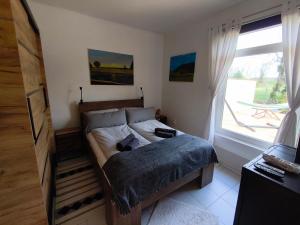 a bedroom with a bed and a large window at Somló Home in Somlószőlős