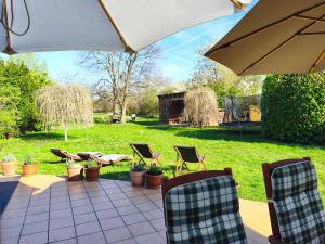 a patio with chairs and an umbrella and plants at Somló Home in Somlószőlős