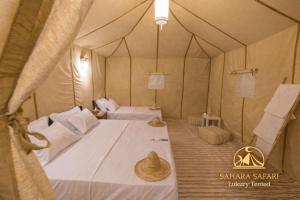 a bedroom with a large bed in a tent at Sahara Safari Luxury Camp & Activities in Merzouga