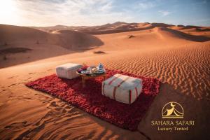a desert scene with two beds in the desert at Sahara Safari Luxury Camp & Activities in Merzouga