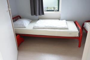 a small bed in a small room with a window at Kustverhuur, Park Schoneveld, Stern 233 in Breskens