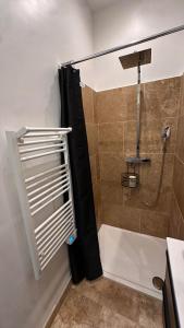 a bathroom with a shower with a black shower curtain at Maison T2 avec terrasse et cours de 50m2 in Sorgues +9 photos
