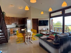 a living room with a couch and a kitchen with yellow chairs at Casa Maricarmen villa in Tacoronte