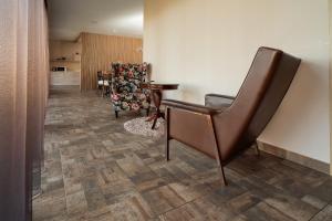 a waiting room with a chair and a table at Žvėrinčiaus vila in Birštonas