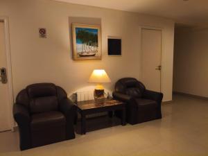 a living room with two chairs and a table and a lamp at Lido in Mar del Plata +15 photos