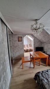 a living room with a wooden table and a chandelier at Guest House Krista in Jūrmala