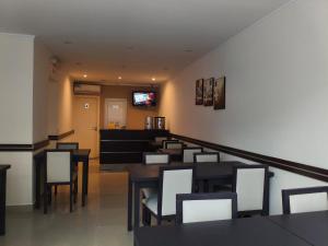 a dining room with tables and chairs and a television at Lido in Mar del Plata