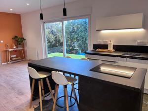 a kitchen with a black counter and stools at Appartement proche de Colmar in Horbourg