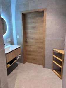 a bathroom with a wooden door and a sink at Appartement proche de Colmar in Horbourg +6 photos