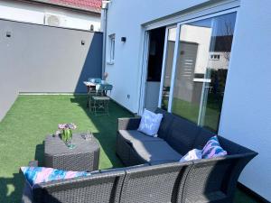 a patio with a couch and a table on a lawn at Appartement proche de Colmar in Horbourg