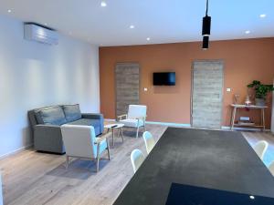 a living room with a couch and a table and chairs at Appartement proche de Colmar in Horbourg