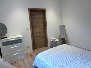 a bedroom with a bed and a dresser and a door at Appartement proche de Colmar in Horbourg
