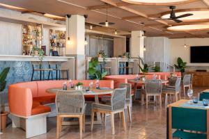 a restaurant with orange booths and tables and chairs at FERGUS Style Palma Beach - Adults Only in Can Pastilla