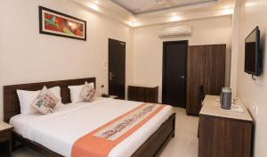a bedroom with a large bed and a tv at Platinum Royal Excellency in Udaipur