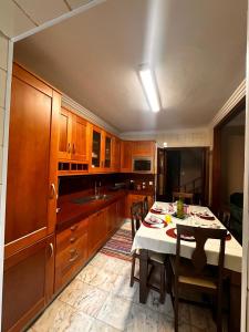 a kitchen with wooden cabinets and a table with chairs at Azor International House in Ponta Delgada +63 photos