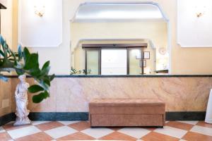 a lobby with a mirror and a stool at Hotel RomAntica in Rome