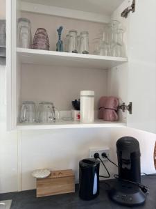 a kitchen counter with shelves filled with glass jars at Noa aan Zee in Westerland