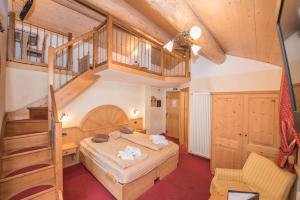 a bedroom with a large bed and a staircase at Hotel Capriolo in Livigno +43 photos