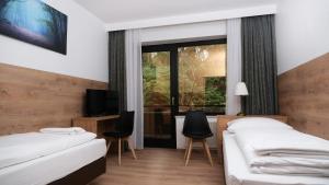 a hotel room with two beds and a window at Forest Monteurzimmer & Fewo für Firmen & Gruppen in Bad Bevensen