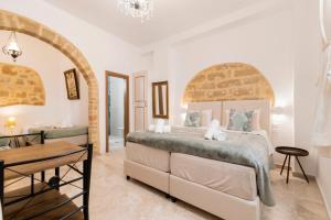 a bedroom with a large bed and a table at Kristina´s rooms in Rhodes Town