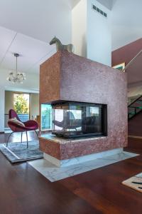 a fireplace in a living room with a red chair at Villa Sirena Apartments in Pärnu