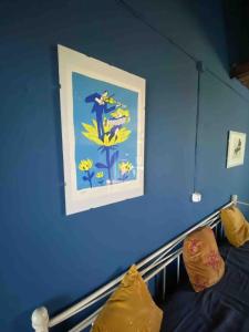 a blue wall with a picture on the wall at The Cottage Guest House in Vale Coelho