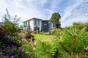 a house with a garden with flowers and plants at Villa Sirena Apartments in Pärnu