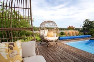 a swing on a deck next to a swimming pool at Villa Sirena Apartments in Pärnu