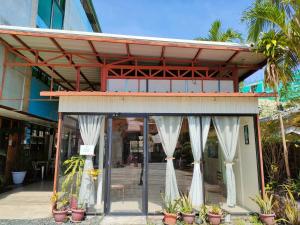 a building with white curtains and potted plants at Axis Pension Hotel in Mactan
