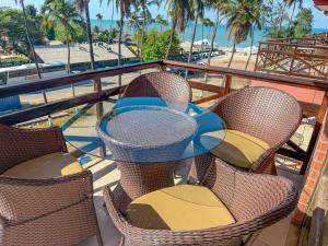 a table and chairs on a balcony with a beach at Kariri beach apt 427 Praia do Cumbuco in Cumbuco