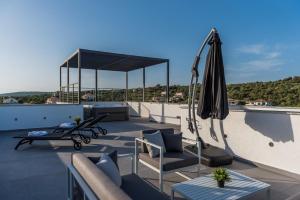a patio with an umbrella and chairs on a roof at Villa Aria in Novalja