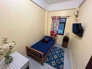 a small room with a blue bed and a table at Tipid Camp Baguio A4,A5,A6 in Baguio +20 photos