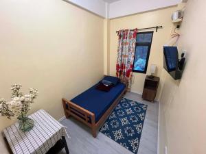 a small bedroom with a blue bed and a window at Tipid Camp Baguio A4,A5,A6 in Baguio