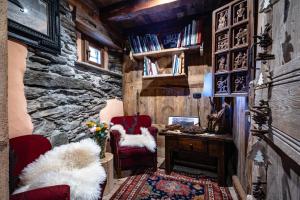 a room with a stone wall and two chairs and a desk at La Luge D'Antan Maison d'Hôtes & SPA in Brusson