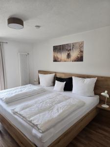 a bedroom with a large bed with white sheets at Ferienwohnung Wilde Hilde inklusive aktivCARD in Arrach