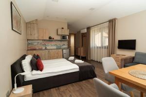 a bedroom with a bed and a living room at Žvėrinčiaus vila in Birštonas