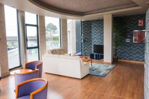 a living room with a white couch and chairs at Alda Carballo in Carballo