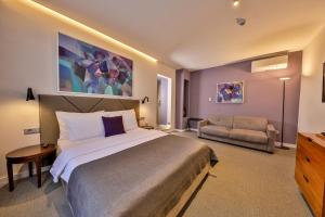 a bedroom with a large bed and a couch at Hotel Botanica in Belgrade