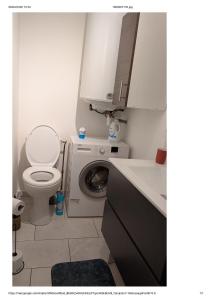 a bathroom with a toilet and a washing machine at Centre Granville in Granville