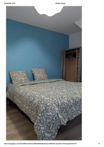 a bedroom with a bed with a blue wall at Centre Granville in Granville