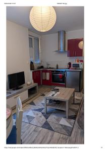 a living room with a table and a kitchen at Centre Granville in Granville