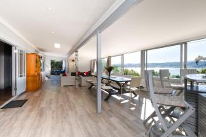 a living room with a table and chairs and windows at The Glen Getaway in Lake Brenton
