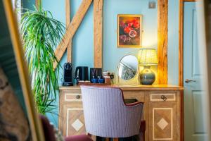 a desk with a mirror and a chair in a room at The Chalk Hare, Royston, Hertfordshire - Acorn Pubs in Royston